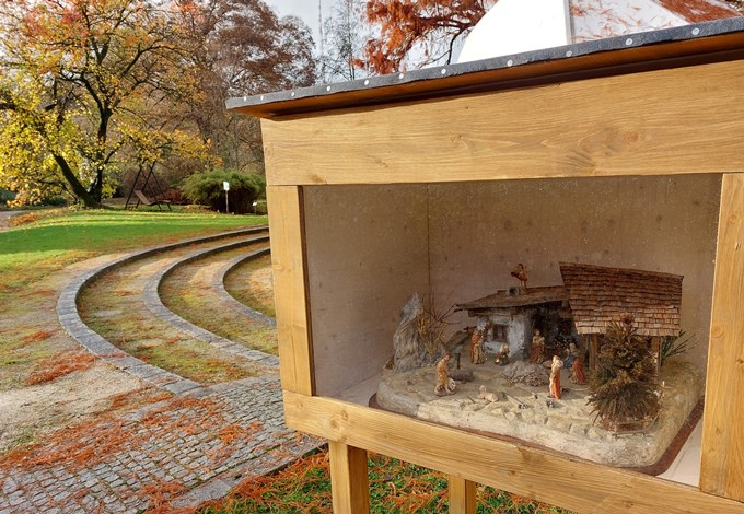 In Holzboxen werden Krippen im Freien gezeigt.