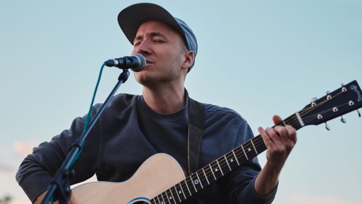 Foto: Claudian Florin Der Musiker am Mikrofon mit Gitarre